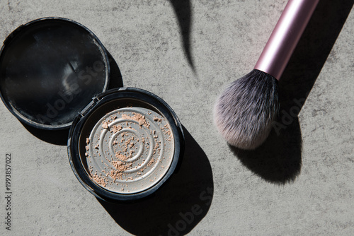 Makeup Powder and Brush on Gray Surface