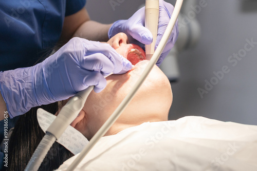 The dentist cleans the patient's mouth.