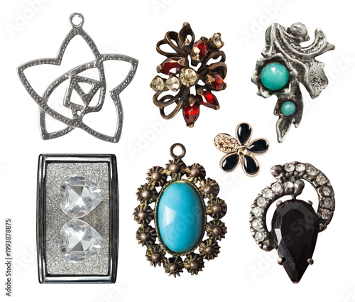 Isolated photo of various metal ornate earrings and pendants on white backdrop.