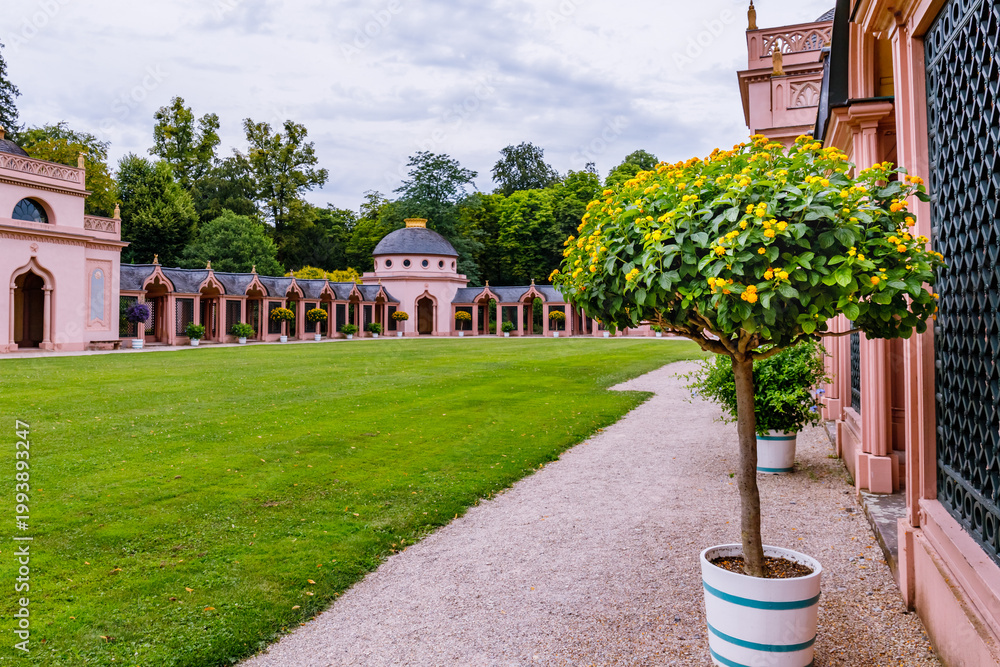 Obraz premium Beautiful garden with colorful trees and small buildings under a cloudy sky