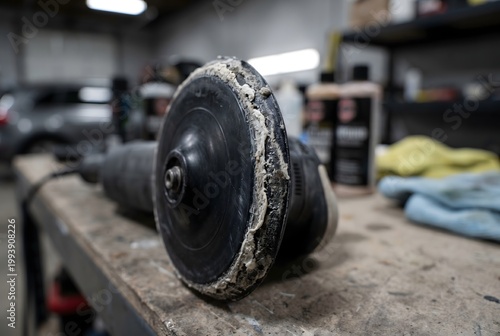 Macro close-up of an automotive polisher backing plate edge encrusted with dried polishing compound