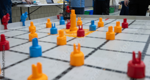 Students play a team robotics game at a school competition in a gymnasium on a weekend afternoon