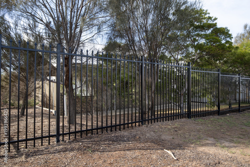Photos A tall black steel spear top security fence along the perimeter of a suburban property in Australia