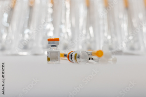 Vials of Tirzepatide medication and insulin syringes for weight loss and diabetes treatment.