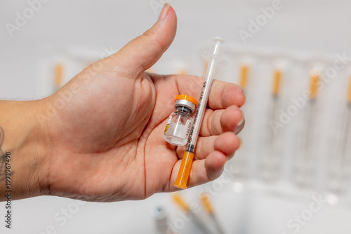 Vials of Tirzepatide medication and insulin syringes for weight loss and diabetes treatment.