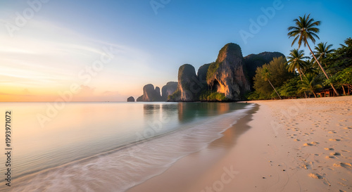 Tropical beach paradise at sunrise with palm trees and limestone cliffs, Krabi, Thailand