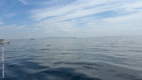 青い空と青い海を走るボートと波景色
