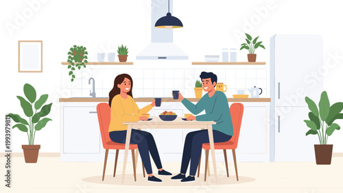 Happy young man and woman sitting at a table and enjoying a meal and coffee together in a modern white kitchen.