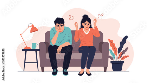 Frustrated young couple sitting on a sofa while experiencing relationship difficulties and looking stressed and unhappy.