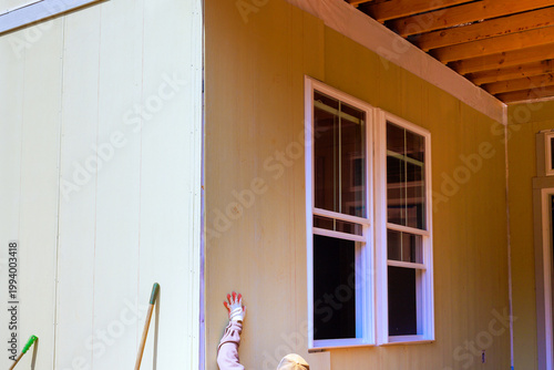 Foto Worker is applying installing siding to t outside wall of house during home impr