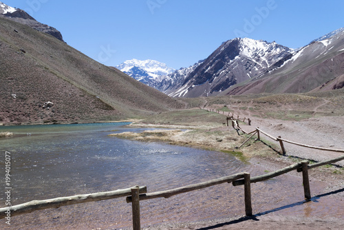 Aconcagua peak towering above mountain lake in andes