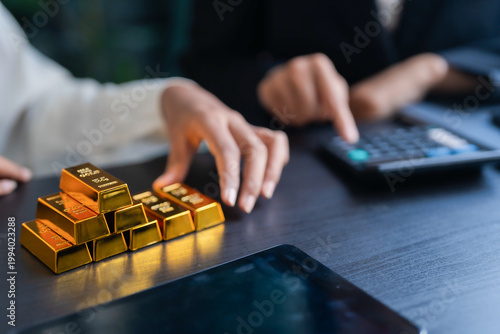 Tableau sur toile Asian businesswoman holding gold bar for investment trading and wealth managemen