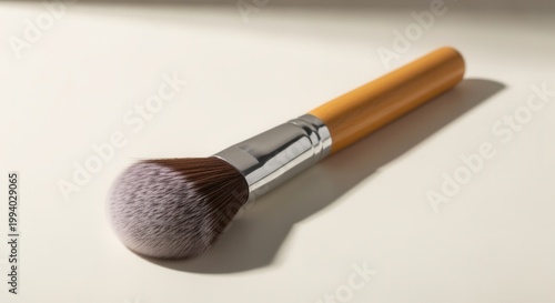 Powder brush close-up on warm surface, a beauty tool in natural light, emphasizing texture and detail, perfect for minimalist lifestyle themes.