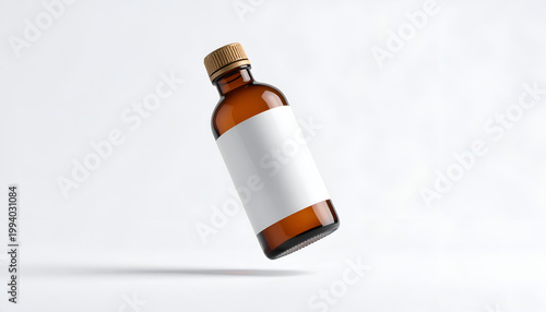 Amber glass bottle with blank white label floating on light backdrop for product mockup aromatherapy extract or medical liquid