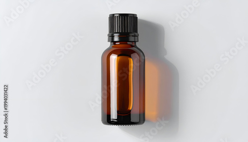 Amber glass bottle with black ribbed cap on white surface in studio setting for essential oils and aromatherapy liquid dispensing