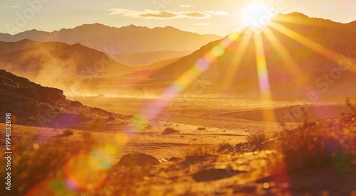 Beautiful golden sunrise over a dusty desert valley with mountain silhouettes