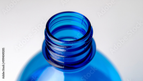Close up macro shot of the threaded neck opening of a blue plastic bottle