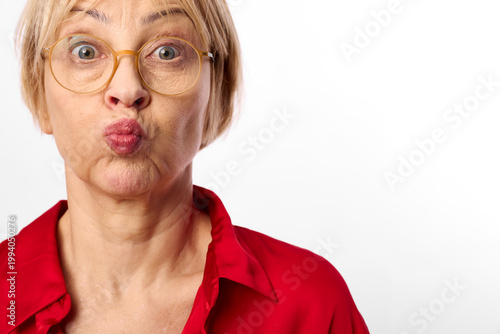 Schilderij op canvas Surprised woman with wide eyes in a red shirt closeup, puckered lips and express