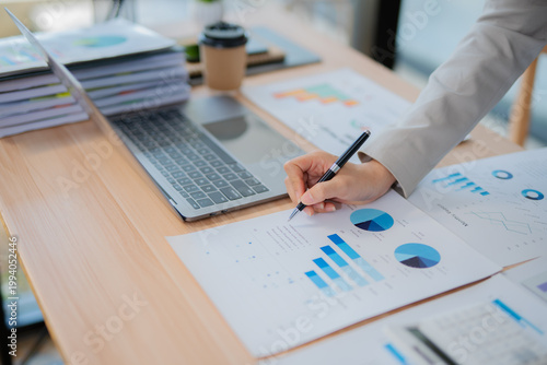 Accountant woman working on financial investment on calculator, calculation, business growth analysis and marketing on graph at office.