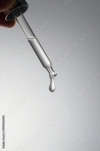Hand squeezes a pipette for serum for skin care (macro) transparent background