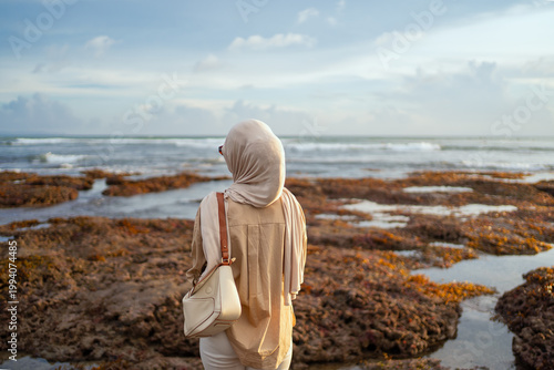Back view Muslim woman looking at ocean Bali Indonesia