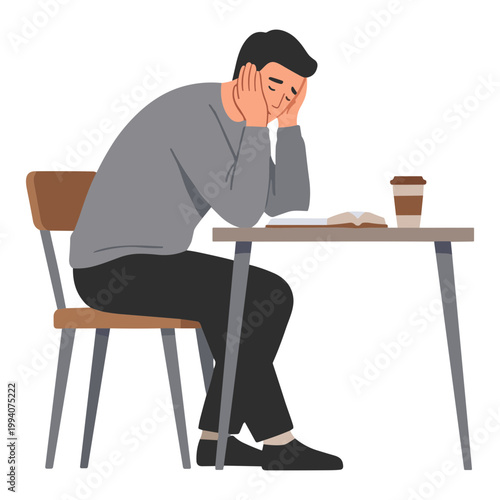 A man sits at a table looking stressed while reading a book next to a coffee cup.