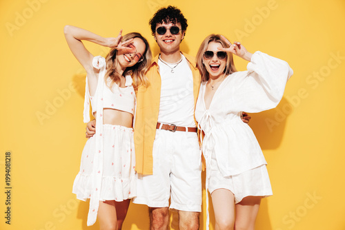 Obraz na plátně Group of young three stylish friends posing in studio