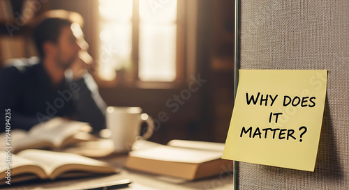 Yellow adhesive sticky note with handwritten text why does it matter placed on wooden table surface for self reflection motivation inquiry and philosophical thinking concept background