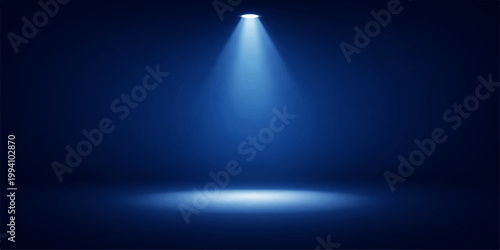 A bright blue spotlight shines on a dark theater stage, creating an illuminated glow against a black backdrop design for a night show scene