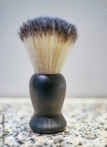 Traditional shaving brush standing upright with soft bristles in clean setting