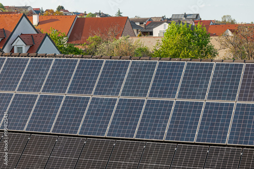 Solar panels installed on rooftops in a residential neighborhood, capturing renewable energy technology, sustainable living and modern eco-friendly housing in a calm suburban setting.