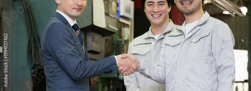 製造業の工場で握手する営業マンと作業員の信頼関係ビジネス契約や合意シーン　業務提携、協力、融資などのbtobの法人営業イメージバナー手元のクローズアップ　カメラ目線