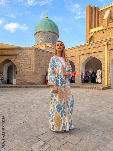 Woman in Uzbek robe at Hazrati Imam Complex with blue dome Tashkent