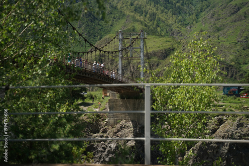 a bridge in the mountains in summer crossing a river