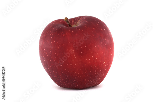 Single ripe red apple with white speckles isolated on a clean white background