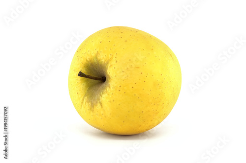 Single golden delicious apple with stem on a clean white background studio shot