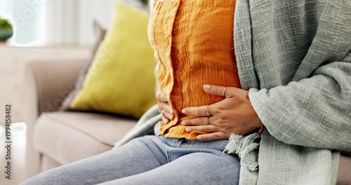 Photos Pain, stomach and hands of woman on sofa with period cramps, discomfort and indigestion