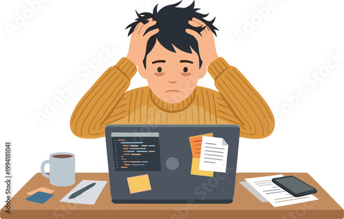 A frustrated man sits at a desk with a laptop and papers, looking stressed.