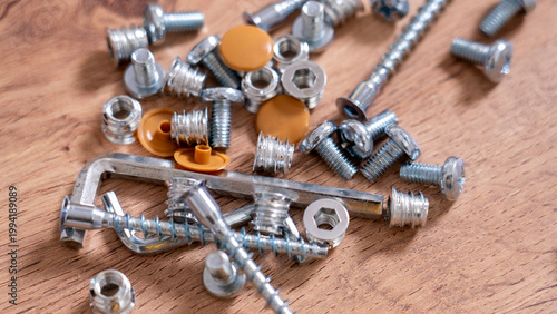 Furniture assembly accessories Wrench self-tapping screw nut bolt plug close-up on wooden background. High quality photo