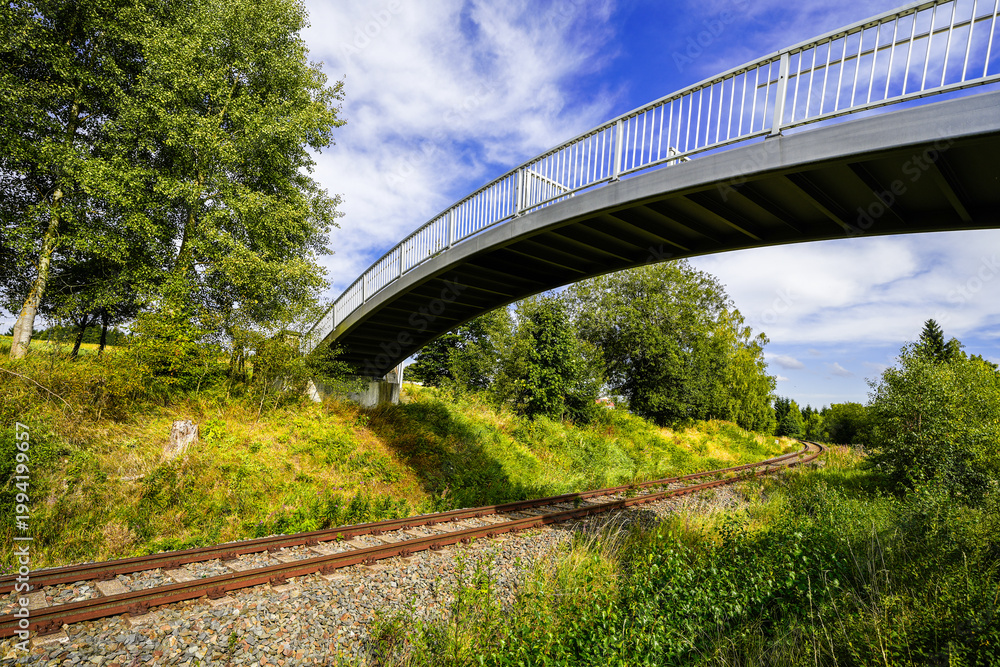 Carta da parati View of the landscape with railway tracks and a pedestrian bridge near Muldenberg in Vogtland