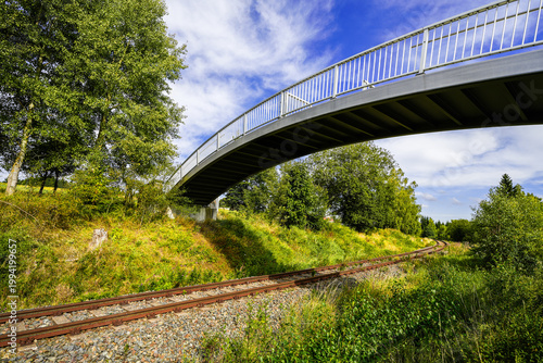 Schilderij op canvas View of the landscape with railway tracks and a pedestrian bridge near Muldenberg in Vogtland