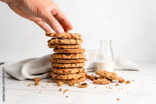 Hand reaching for stack of homemade chocolate chip cookies with