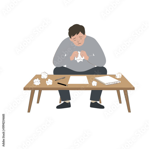 Man sits at wooden table crying with crumpled papers around him