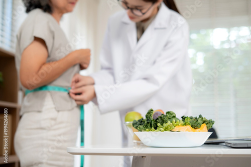 Nutritionist examining senior woman for weightloss planning for health in clinic office, doctor measuring body for slimming diet of elderly, medical wellness care and diagnosis with consultation.