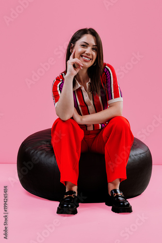 Smiling woman sitting on bean bag in colorful outfit