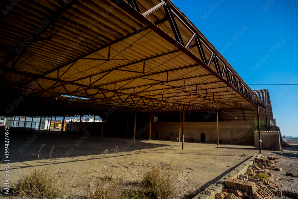 Fototapeta premium Abandoned Industrial Warehouse Interior with Decay