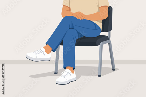 Person sitting in a waiting room, legs crossed, hands clasped, showing patience and casual body language