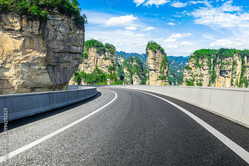 Foto Asphalt highway leading towards majestic sandstone pillars in Zhangjiajie Nation
