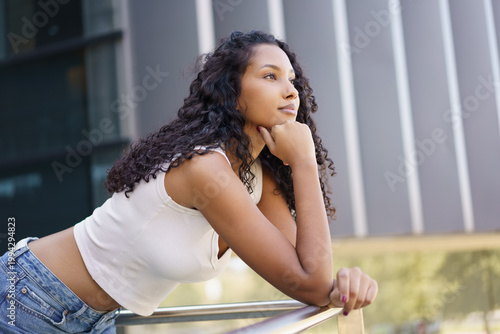 A Contemplative Young Woman Deep in Thought While Immersed in Nature Outdoors and Peering Off