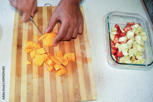 Foto Chef slicing mango on wooden surface